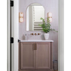 Clérachic Pill-Shaped Wall Sconce pair set at eye level either side of an arched mirror above a timber vanity.