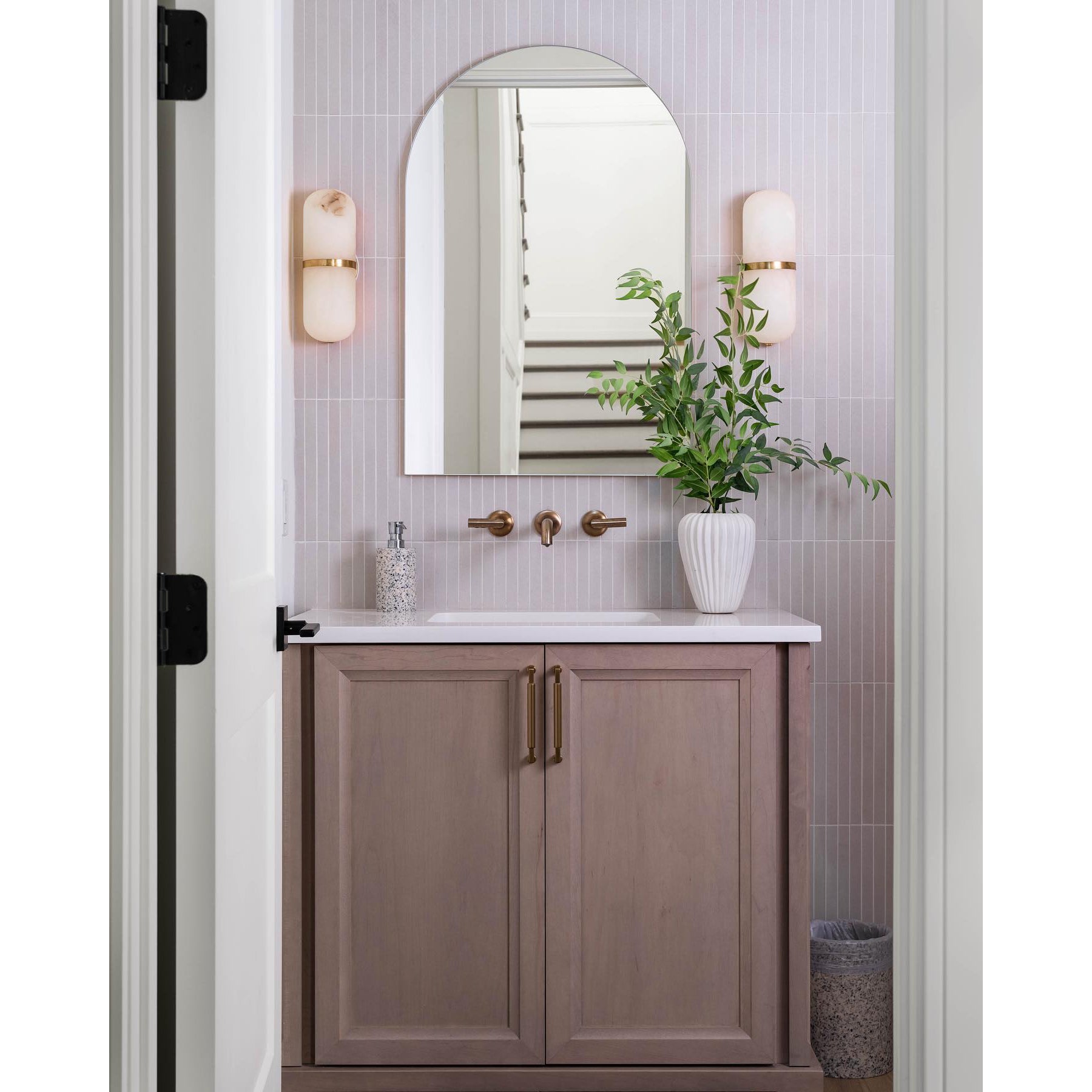 Clérachic Pill-Shaped Wall Sconce pair set at eye level either side of an arched mirror above a timber vanity.