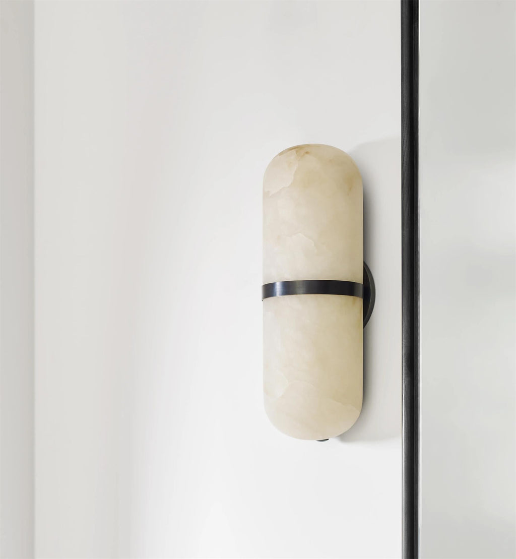 Clérachic Pill-Shaped Wall Sconce seen from an angle on a white wall, showing how little it stands off the surface.