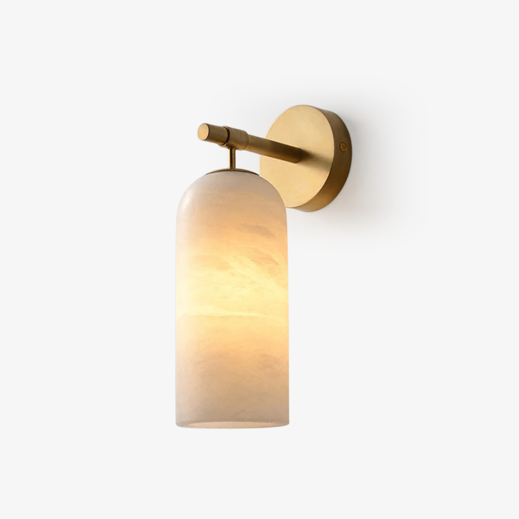Clérachic Pillar wall light lit on white, warm glow rising through the veined alabaster shade.
