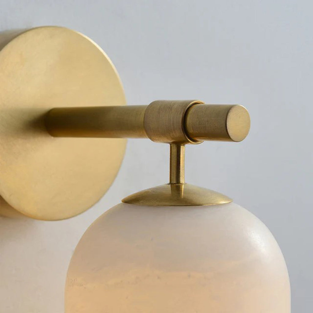 Macro of the Clérachic Pillar arm, knurled brass rod meeting the disc and stone shade.
