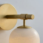 Macro of the Clérachic Pillar arm, knurled brass rod meeting the disc and stone shade.