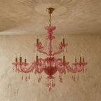 Clérachic pink crystal chandelier, its full tiered arms and crystal drops centred against a limewash backdrop.
