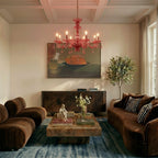 Clérachic crystal chandelier hangs warm red-toned above a coffered-ceiling living room with a burgundy sofa.