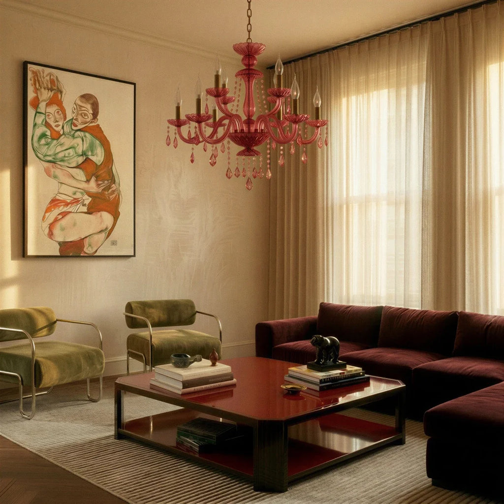 Clérachic pink crystal chandelier lights a living room with olive armchairs, a lacquered coffee table and sheer curtains.