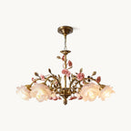 Front view of this Clérachic chandelier on a white backdrop, with frosted rose-shaped glass shades, ceramic pink roses and antique gold branches.