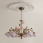 Clérachic chandelier with pale lilac glass rose shades, unlit, hanging from a white fluted ceiling rose on a soft cream wall.