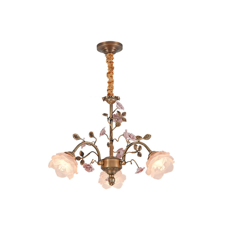 Clérachic chandelier with a fabric-wrapped chain on a white backdrop, ceramic roses in soft pink and frosted glass rose shades lit.