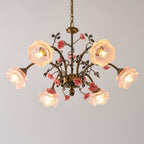Close view of a Clérachic chandelier with lit pink frosted glass rose shades, with ceramic roses and leaves on antique gold arms.