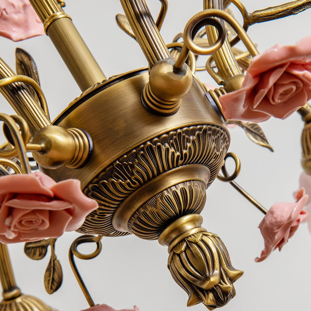 Underside of this Clérachic chandelier, with a carved antique gold centre, a bud-shaped finial and pink ceramic roses around it.