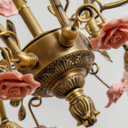 Underside of this Clérachic chandelier, with a carved antique gold centre, a bud-shaped finial and pink ceramic roses around it.