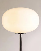 Clérachic table lamp in close detail, showing the smooth white opal glass globe shade catching the light.