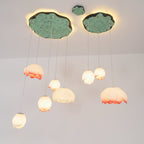 Looking up at this Clérachic water-lily pendant cluster, pink-tipped and white glass buds glow warm beneath two green lily-pad canopies.