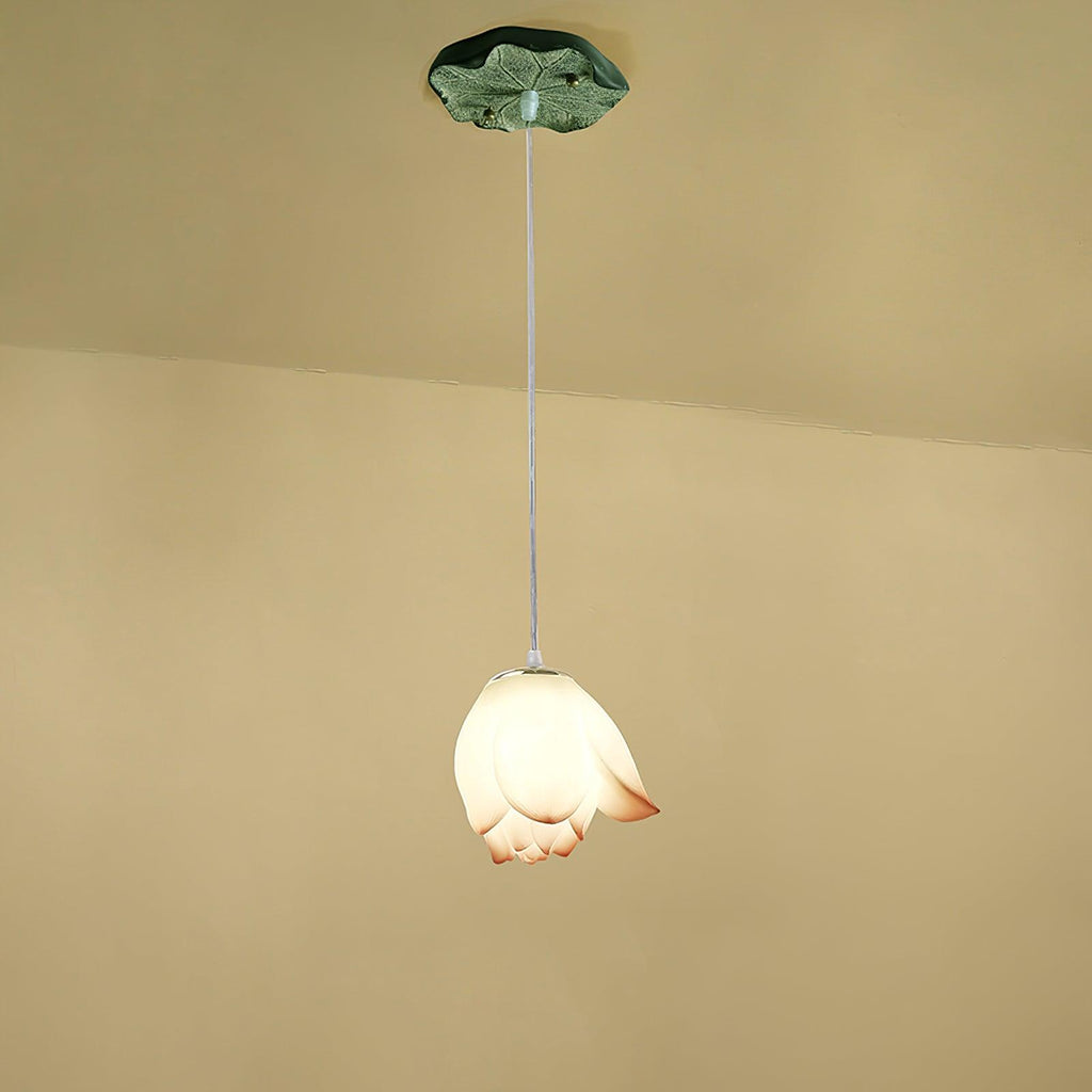 A single Clérachic water-lily pendant with a closed white bud and a faint coral tip, hanging from a small green lily-pad canopy.