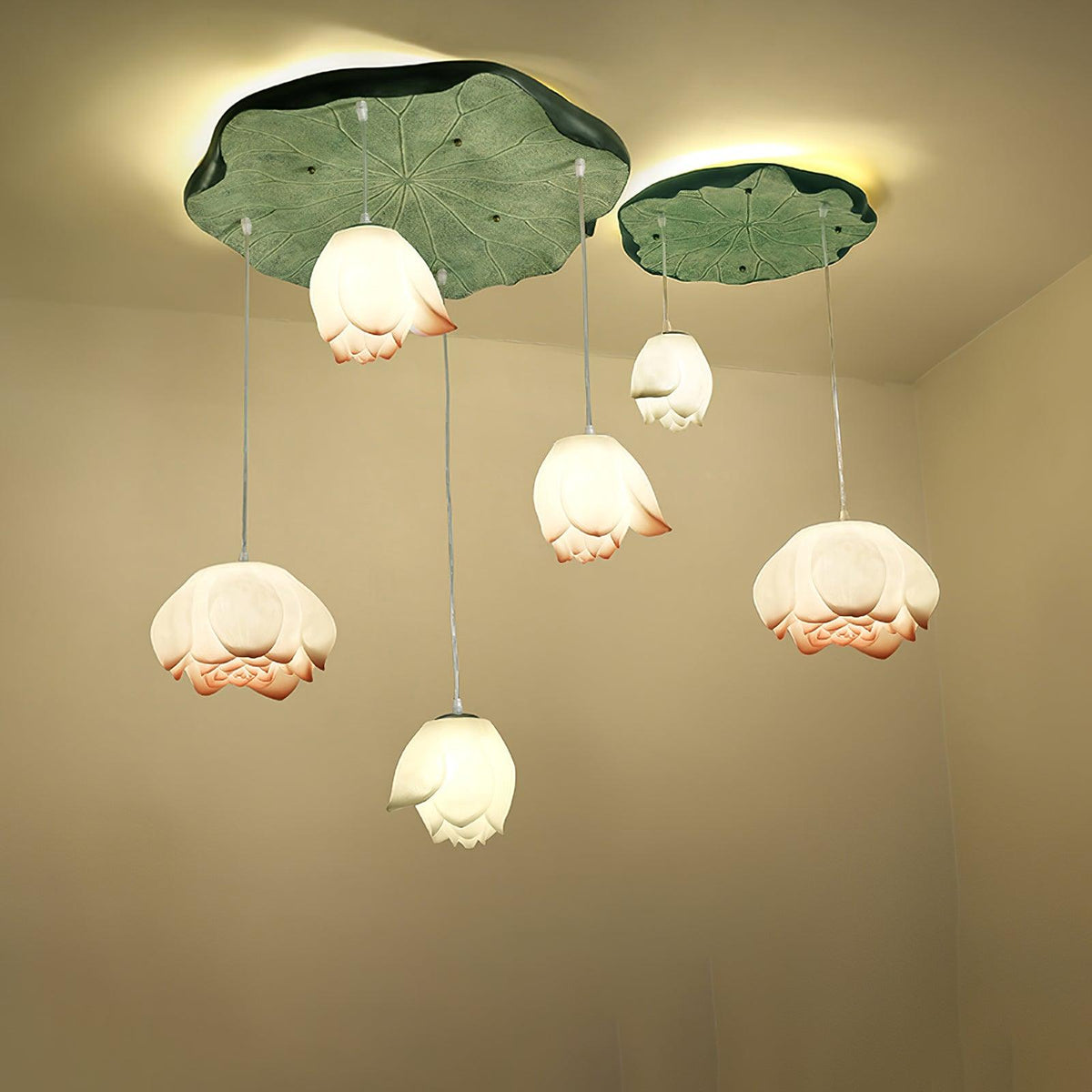 Six Clérachic water-lily pendants arranged beneath two green lily-pad canopies, with white and coral-tipped buds at different heights.