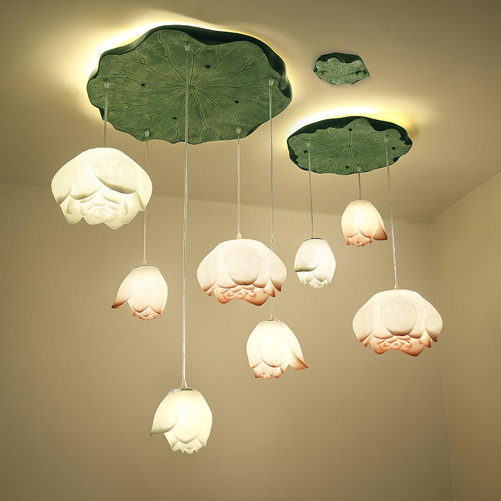 A full Clérachic water-lily pendant cluster glows warm beneath a large lily-pad canopy and a smaller one, with a third leaf above.