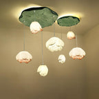 The Clérachic water-lily pendant cluster seen from a slightly different angle, with nine glowing buds under two green lily-pad canopies.