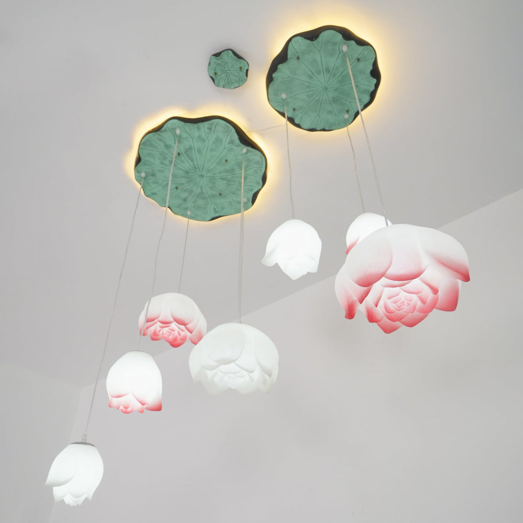 The Clérachic water-lily pendants hang in varied sizes beneath two lily-pad canopies, with pink-edged blooms and smaller white buds.