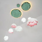 The Clérachic water-lily pendants hang in varied sizes beneath two lily-pad canopies, with pink-edged blooms and smaller white buds.