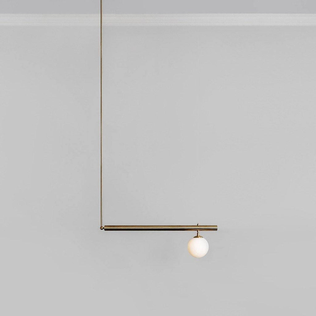 Single-globe Clérachic pendant on a plain grey background, with a long gold rod and one short bar holding an opal globe.