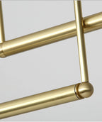 Close view of the brushed gold tubes and the rounded joint where two bars meet on this Clérachic pendant.