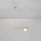 Single-globe Clérachic pendant hung from a round gold ceiling cap, with a gold rod and a short bar, on a pale grey wall.