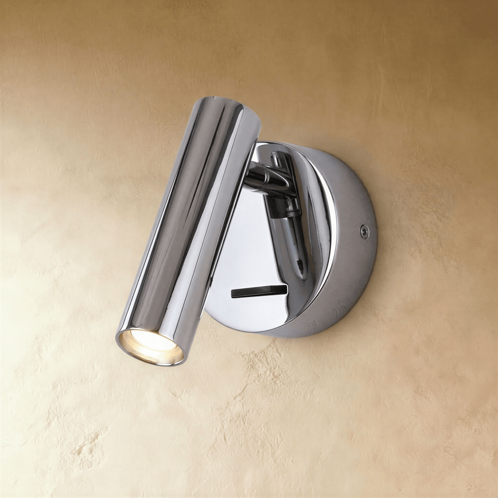 Clérachic polished chrome wall reading light with a mirror-bright cylinder head and round backplate on a limewash wall.