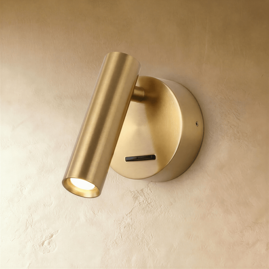 Clérachic brushed brass wall reading light, a slim cylinder head tilted down over a round backplate and slide switch.