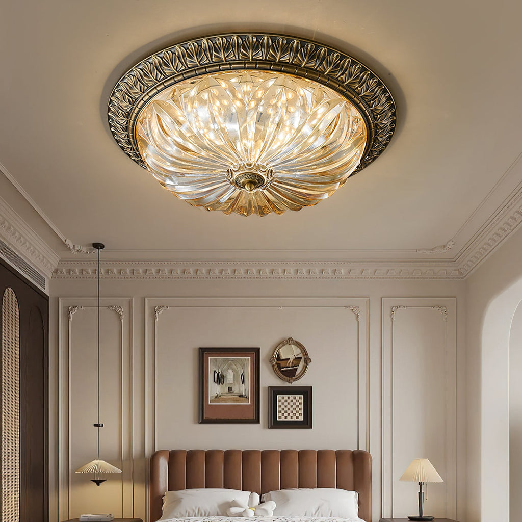 Seen from below, this Clérachic ceiling light hangs in a panelled bedroom above a tan channel-quilted headboard and two table lamps.