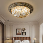Seen from below, this Clérachic ceiling light hangs in a panelled bedroom above a tan channel-quilted headboard and two table lamps.