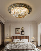 Narrow view of this Clérachic flush light over a bed with a leaf-print duvet, a tan headboard and a panelled wall.