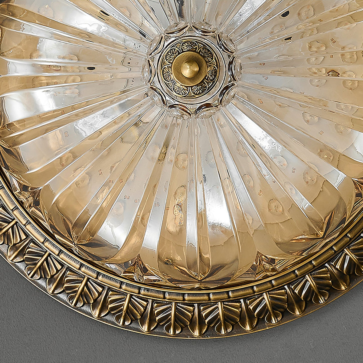 Close view from below of the pleated glass and the small brass centre boss on this Clérachic ceiling light.