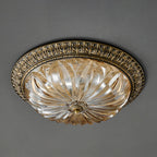 Unlit Clérachic ceiling light on a grey ceiling, showing the clear ribbed glass bowl and the cast brass rim.