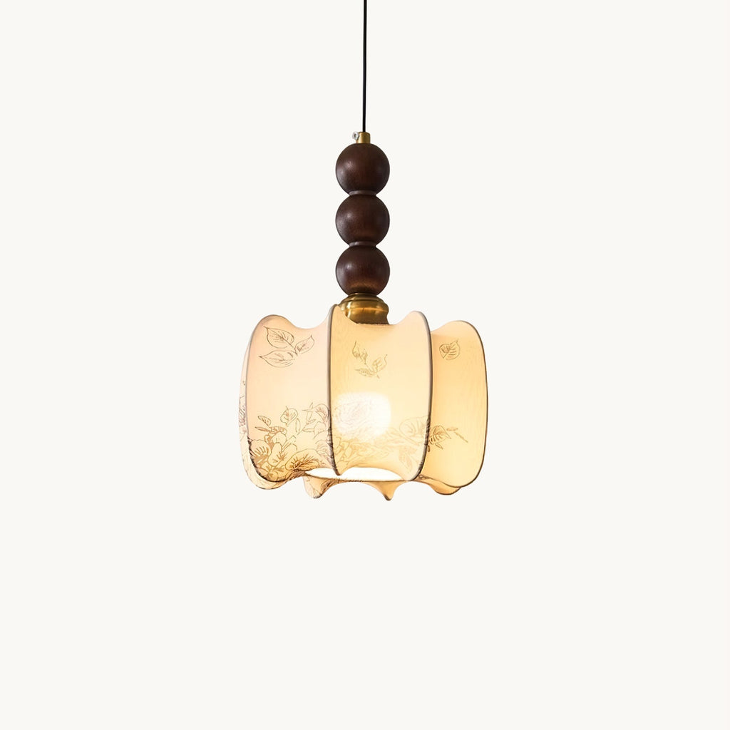A Clérachic pendant with a gathered cream fabric shade printed with fine botanical sketches, hung beneath three walnut-toned wooden beads, on white.