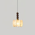 A lit Clérachic pendant with a gathered cream shade and three walnut beads, hung against a light grey backdrop.