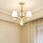 The Clérachic Pleated Blue Fabric Chandelier's 3-light version mounted in a bedroom corner, its pleated shades glowing beside a sheer curtain.