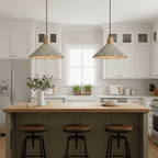 Two Clérachic pendants hang over an olive-green kitchen island with three black stools in a white kitchen.