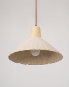 Seen from below, a cream-toned Clérachic pendant shows its bulb and the pale inside of its wide, pleated shade.