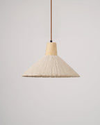 A cream-toned wide-shade Clérachic pendant, unlit, with a wooden cap and brown cord against a plain light grey backdrop.