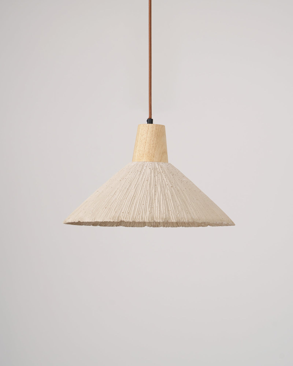 A cream-toned wide-shade Clérachic pendant, unlit, with a wooden cap and brown cord against a plain light grey backdrop.