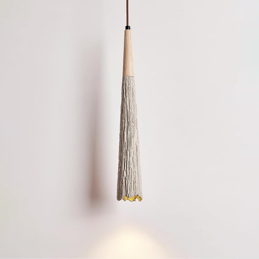 Close view of the slim tapered shade on this Clérachic pendant, with a wooden collar and a warm glow at the tip.