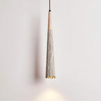 Close view of the slim tapered shade on this Clérachic pendant, with a wooden collar and a warm glow at the tip.