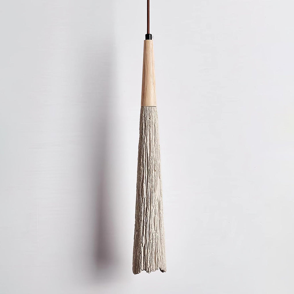 The textured, bark-like surface of this slim Clérachic pendant, seen close up with its wooden collar and black fitting.