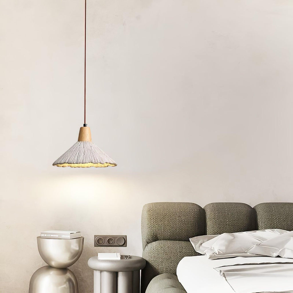 A single wide-cone Clérachic pendant hangs by a sage-green sofa and sculptural metallic side tables.
