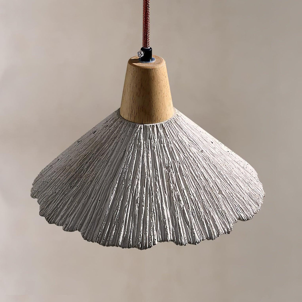 Close view of the ridged, pleated surface and wavy rim of this Clérachic pendant, with a braided cord above the wooden cap.