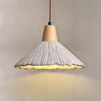 Side-on close view of this Clérachic pendant, its grey ridged shade lit and casting a warm pool of light below.