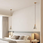 Two bell-shaped Clérachic pendants flank a bed in a bedroom with long grey curtains and a soft headboard light.