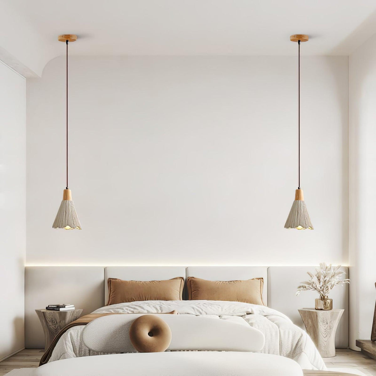 A pair of bell-shaped Clérachic pendants hang on wooden canopies above a bed with tan cushions.