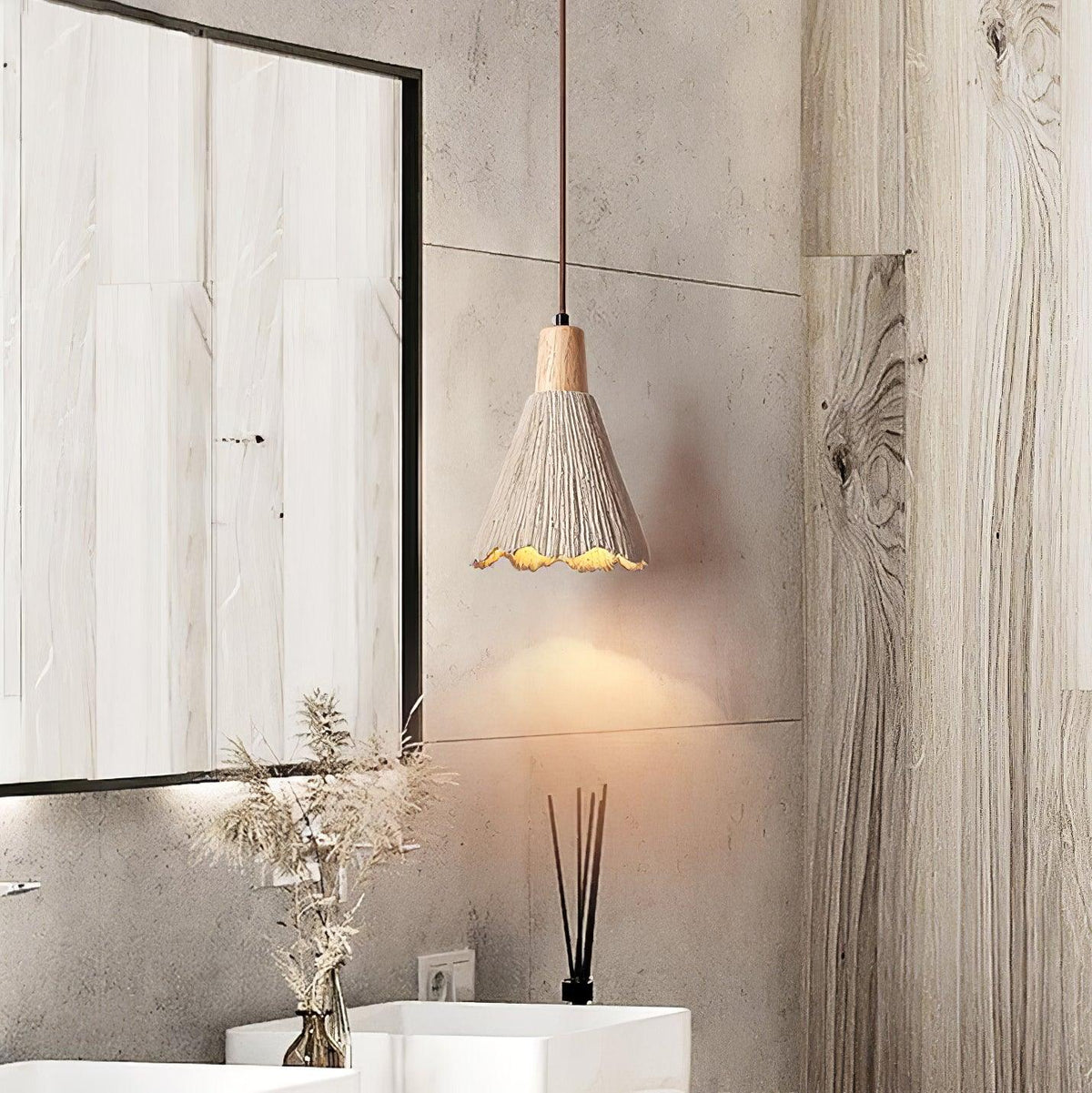 A bell-shaped Clérachic pendant hangs in a bathroom with wood-grain panelling, above a basin and a reed diffuser.