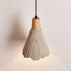 Close view of the tapered, ridged shade and wooden cap on this Clérachic pendant, lit softly from below.